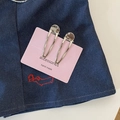 Close-up of polished silver metal teardrop hair clips on pink card over denim - Hollow Teardrop