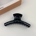 Close-up of black hair claw clip with blue polka dots on a minimalist background - Black Hanger Style