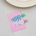 Detail view of 2-pack floral seamless hair clips in blue daisy and pink floral patterns - Floral Style