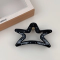 Detail of star-shaped hair claw clip with black and white polka dots and gold spring - Black Star Style