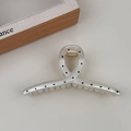 Detail view of the French polka dot claw clip showing golden metal spring and smooth teeth - Creamy White Cross Style