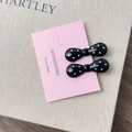 Détail de deux pinces à cheveux à pois noirs et blancs de style français sur carte - Nœud Noir Style A