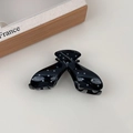 Dettaglio di un fermaglio per capelli a pois neri e bianchi in stile francese su sfondo neutro - Stile a V Nero