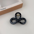 Dettaglio di un fermaglio per capelli nero a pois bianchi con molla in metallo dorato - Stile Fiocco Piccolo Nero
