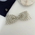 Close-up of a vintage black polka dot hair bow clip made of sheer organza fabric - Beige
