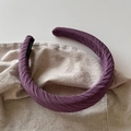Detail der gewellten Faltenstruktur und des handgefertigten Labels am lila Stirnband - Dunkelviolettes Plissee-Modell