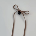 Detail van een bruine leren strik haarclip met lange linten in elegante balletstijl - Donkere Koffie