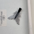 Dettaglio della forcina a farfalla a pois neri con clip a becco d'anatra in metallo nero - Farfalla Bianca