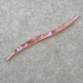 Detail of French handmade acetate hair pin featuring marbled texture and engraved logo - Pink