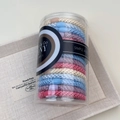 Close-up of colorful braided elastic hair ties in a clear cylindrical storage container - Blue And Pink