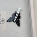 Dettaglio del fermaglio per capelli a farfalla a pois bianchi e neri con clip in metallo bianco - Stile Farfalla Nera