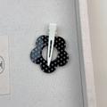 Dettaglio del fermaglio per capelli a fiore a pois bianchi e neri con clip in metallo - Stile Fiore Nero