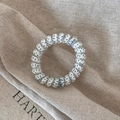 Detailed close-up of a transparent spiral hair tie with navy blue polka dots on burlap - White Gray Dot