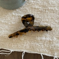 Dettaglio della molletta per capelli tartarugata con logo su superficie intrecciata - Stile A Tartarugato Scuro