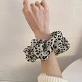 Dettaglio di un elastico per capelli oversize leopardato indossato sul polso - Leopardo Beige