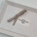 Close-up of a vintage leather bow hair clip in beige with a metallic spring clasp - Milk Coffee