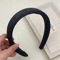 Close-up of handmade dark grey fabric headband with red polka dots and interior label - Wide Style / Black