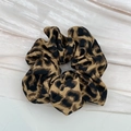 Dettaglio dell'elastico per capelli leopardato con texture morbida e design a pieghe - Scrunchie Leopardo Scuro