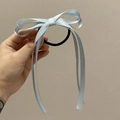 Detailansicht eines hellblauen Satin-Haargummis mit Schleife und langen Bändern - Blau