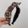 Dettaglio del cerchietto leopardato con nodo intrecciato e texture in tessuto morbido - Stile Fiocco Cerchietto (XY-364)