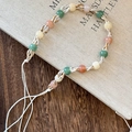 Detalle de diadema bohemia trenzada a mano con cuentas de colores sobre un libro - Estilo Tejido de Cuentas Blancas (B款)