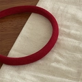 Pink fabric headband with ribbed texture for women shown in a close-up overhead shot - True Red