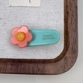 Macro shot of a blue acetate hair clip with a pink flower and handmade lettering - Orange Pink Flower Hair Clip