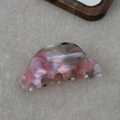 Detail view of pink marbled acetate hair claw clip showing natural texture and teeth - Pink