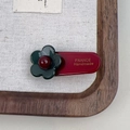 Dettaglio di un fermaglio per capelli a fiori fatto a mano con scritte dorate in rilievo - Verde Scuro Floreale