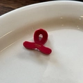 Macro shot of small red acetate hair claw clip with golden Sunshine Handmade lettering - Red