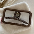Detail of French vintage leopard print hair claw clip on white sherpa background - Dark Leopard Bar Style