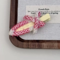 Détail d'un nœud en tissu à carreaux roses sur une pince à cheveux en métal jaune - Rose rouge
