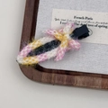 Detail of pink and yellow woven tweed bow hair clip on a natural wooden tray with soft lighting - Pink & Yellow Plaid