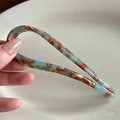 Minimalist U-shaped acetate hair pin in blue amber floral finish held by hand - Mint Green Brown Gradient