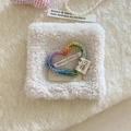 Macro detail of rainbow knit heart hair clip with a metal BB pin on a soft white texture - Heart Style / Colorful
