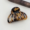 Detailed macro view of the tortoiseshell resin hair claw clip with a glossy finish - Dark Leopard Print