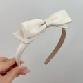 Detailed view of a creamy white satin double bow headband with non-slip lining - White