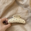 Close-up of cream shark hair clip with colorful rhinestones on a linen background - Semicircle Style