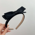 Close-up of black satin double-layered bow headband showing fabric texture and design - Black
