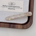 Detail of milk tea acetate hair clip with gold foil inlay on a wooden display - Beige