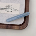 Close-up of a blue acetate hair clip with golden Barrette La France lettering on wood - Blue