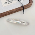 Dettaglio della molletta per capelli in acetato con texture marmorea e riflessi - Bianco Sirena