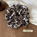 Detailopname van een luipaardprint haarelastiekje van chiffon op houten tafel - Zwart en Wit
