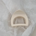 Detailed close-up of cream-colored arched hair claw clip on white textured paper - Cream Semicircle Style