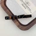 Close-up of tortoise shell barrette with Barrette La France text on wood tray - Dark Tortoiseshell