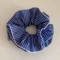 Detail eines blau-weiß gestreiften Stoff-Haargummis mit feiner weißer Nahtkante - Blau Gestreift