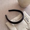 Detalle de diadema de cuero negro con textura de lichi sobre fondo de tela crema - Diadema Negra