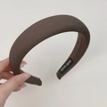 Detail of a dark brown padded fabric headband featuring a handmade label on inner side - Wide Style / Brown