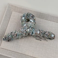 Détail macro d'une pince à cheveux en tweed avec paillettes argentées sur fond de lin - Croisé / Bleu