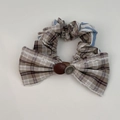 Close-up of checkered bow scrunchie featuring vintage buttons and striped fabric detail - Milk Tea Striped Scrunchie